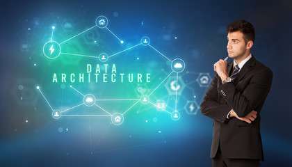 Businessman in front of cloud service icons with DATA ARCHITECTURE inscription, modern technology concept