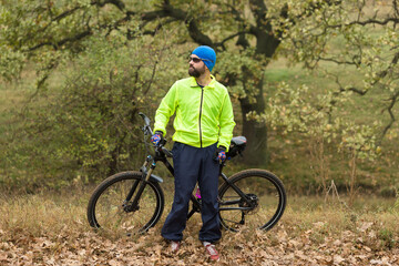 Fototapeta premium Cyclist in pants and fleece jacket on a modern carbon hardtail bike with an air suspension fork rides off-road. 