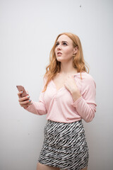 Obraz premium Beautiful long red health hair of young attractive woman isolated white background pink shirt zebra skirt posing mockup advertisement smartphone