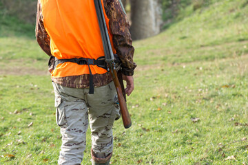 Hunting period, autumn season open. A hunter with a gun in his hands in hunting clothes in the...