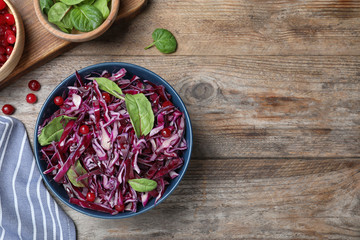 Fresh red cabbage salad served on wooden table, flat lay. Space for text