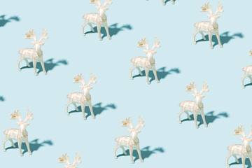 Pattern made of silver reindeer toys on blue background. Christmas and New Year concept.