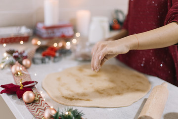 Hand pouring cinnamon with out of focus lights in background