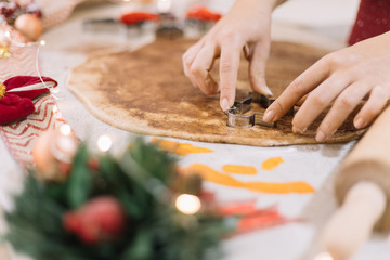 Lady shaping CHristmas man biscuits in cookie dough.