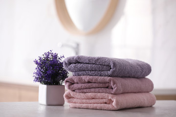 Stack of fresh towels on table in bathroom