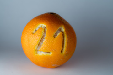 Zahl 21 für einen Adventskalender in die Schale frischer Orangen geschnitzt