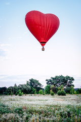 Fototapeta premium Heart shaped balloon soars in the sky