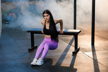 Young sport woman making exercise using bench in gym.