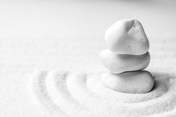 Fototapeta na wymiar Stack of white stones on sand with pattern, space for text. Zen, meditation, harmony