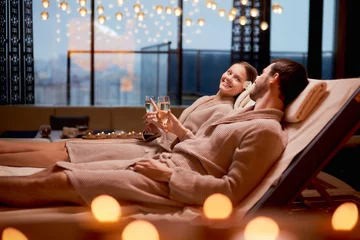 Fototapeten Spa, entspannen, Konzept genießen. Ehepaar zusammen entspannen im Spa-Salon, auf Betten liegend Champagner trinken, Kerzen benutzen © alfa27