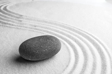 Fototapeta na wymiar Grey stone on sand with pattern, space for text. Zen, meditation, harmony