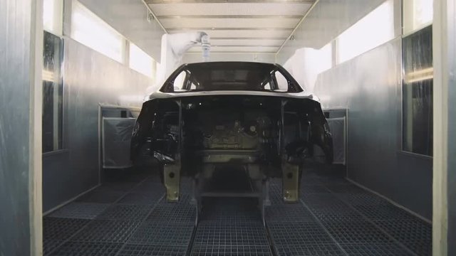 Automobile factory, industrial robots paint the car body. (time-lapse)