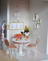 Handmade dollhouse for girls. Miniature kitchen with small desserts on the table
