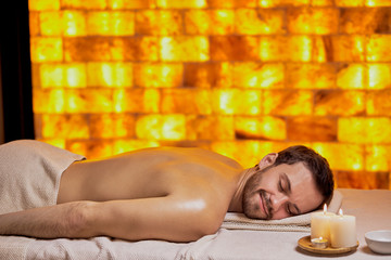 Caucasian male came to spa salon to relax and get massage in beauty salon, lying on spa table