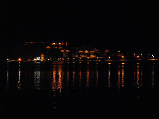 Fototapeta na wymiar A breathtaking view of a summer night with street and house lights on a small island.