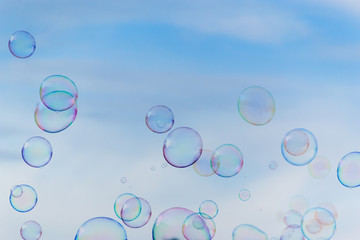 Colorful soap bubbles against blue sky background