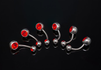 Set of belly piercing on black background. Body jewelry.