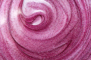 Texture of lip gloss. Smudged makeup product sample. Sparkling background