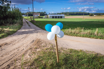 White and blue balloons on the rural crossroads in Nowe Miasto County in Poland