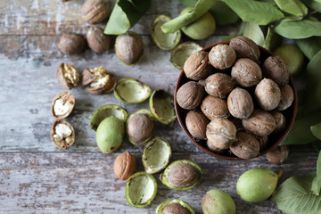 Selective focus. Walnuts in a bowl. The leaves of the walnut tree. Walnuts in a green peel. Harvest walnuts.