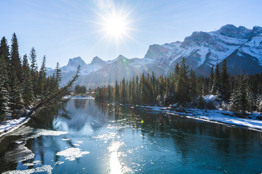 Canada Landscape. View of snow covered mountain scenery, Bow river and Three Sisters in winter. Beautiful sunny day in Canadian Rockies. Canmore, Alberta, Canada.