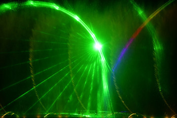 Colorful water fountains. Beautiful laser and fountains show. Large multi colored decorative dancing water jet led light fountain show at night. Dark background.