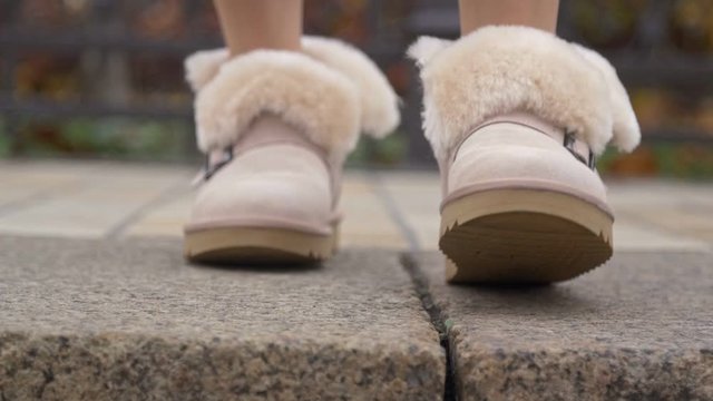Woman showing her beige ugg winter boots close up