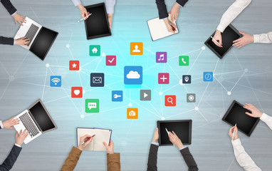 Group of people with devices in hands working in team on tablets, laptops with application concept
