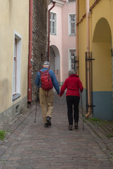 Senior couple walking and holding hands while exploring their travel destination of Old Town Tallin, Estonia