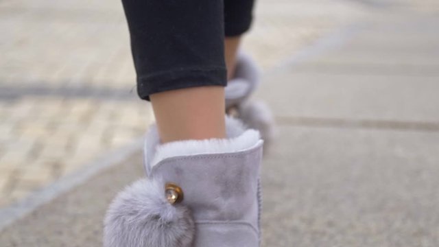 Female legs walks in ugg winter boots close up