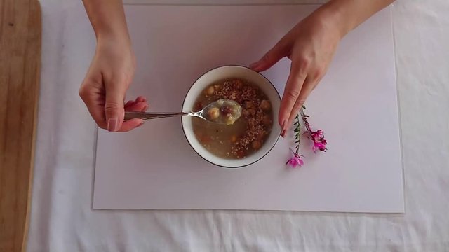 Turkish Noah's Pudding or ashure served with bowl and spoon up and eating.