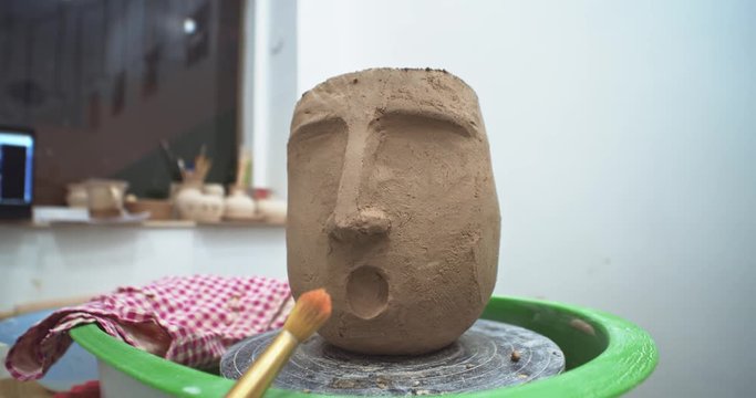 Artist created human face vase sculpture with clay. Sculptor finished new ceramic object in workshop. Modern art studio education. Talented ceramist presentating new exterior interior flowerpot.