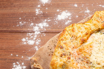 Closed calzone pizza on wooden background