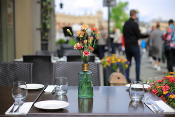 Served table summer cafe with flowers