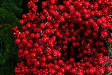 Holly berries with pieces of ice, New Year Christmas scenery. Red artificial holly berries braided...