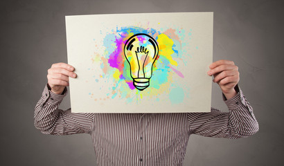 Person holding a paper with a drawn colorful idea concept