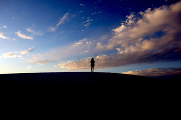 silhouette of the woman on the hill on the sky 