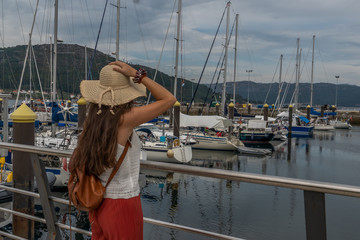 young girl with hat enjoying the views of the port