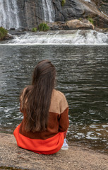 young girl enjoying a lake and a waterfall