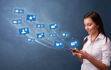 Young person using phone with flying social media icons around