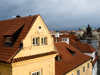 Rooftops of Mala Strana neighborhood with view of Charles Bridge at the background