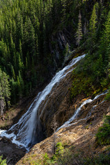 Fototapeta na wymiar Beautiful View of a waterfall near Grassi Lake during a vibrant summer day. Taken in Canmore, Alberta, Canada.