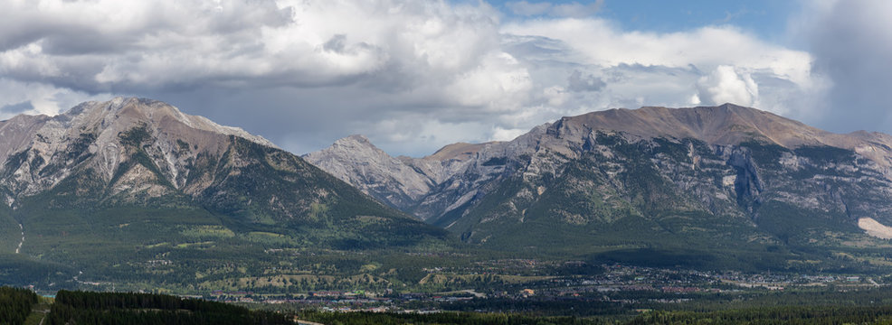 Beautiful Panoramic View of a small city in the Canadian Rocky Mountain Landscape during a cloudy summer day. Taken in Canmore, Alberta, Canada. © edb3_16
