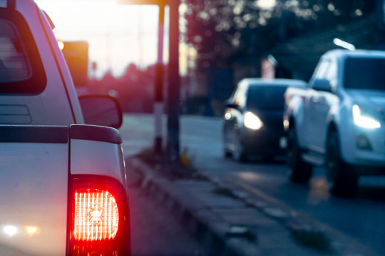 Pick Up Car On The Road With Light Break At In Evening. With Other Cars Passing The Traffic Signal Coming From The Opposite Side.