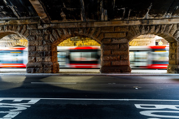 Light rail tram transportation in motion through stone archway