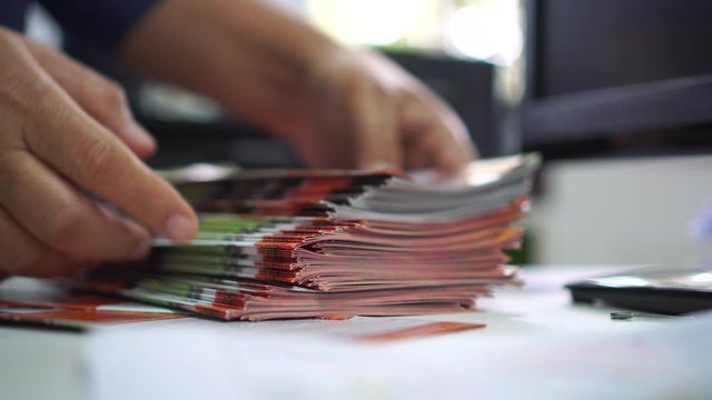 Pile of presentation brochure document concept for Businessman hands working in business Documents on Stacks Brochures papers files for checking achieves reports on busy work computer desk office, 4k