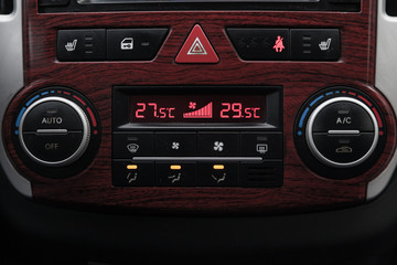 Control buttons for the climate control car with automatic control, the display on which shows the temperature in degrees Celsius with the number 18 and the buttons to zoom and reduce
