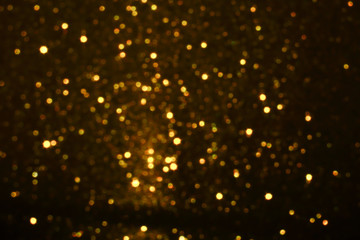 gold Sparkling Lights Festive background with texture. Abstract Christmas twinkled bright bokeh defocused and Falling stars. Winter Card or invitation	