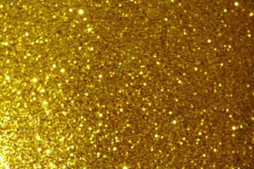 gold Sparkling Lights Festive background with texture. Abstract Christmas twinkled bright bokeh defocused and Falling stars. Winter Card or invitation	