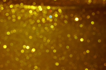 gold Sparkling Lights Festive background with texture. Abstract Christmas twinkled bright bokeh defocused and Falling stars. Winter Card or invitation	